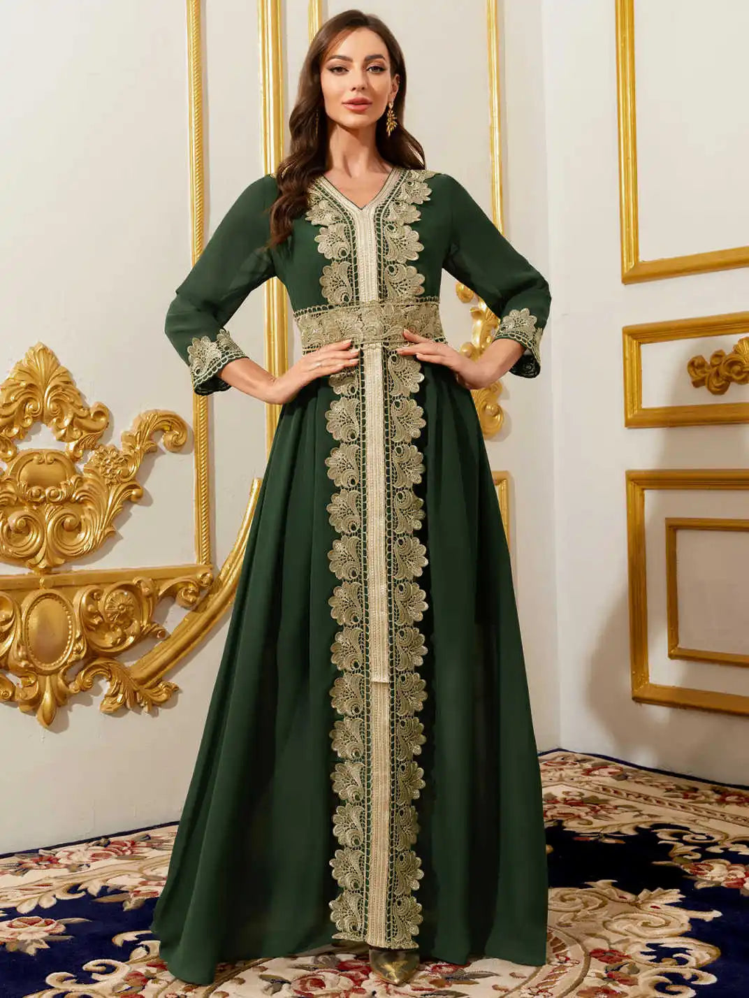 Woman wearing a green dress with intricate lace details in a decorated room.